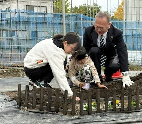 市長と参加者が苗木を植えている写真