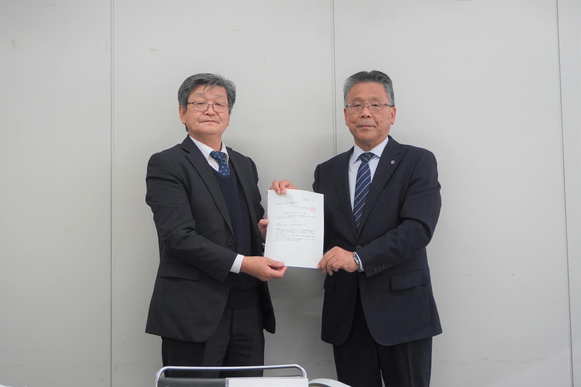 小野田教育長（右） から諮問書受け取る 福田会長（左）