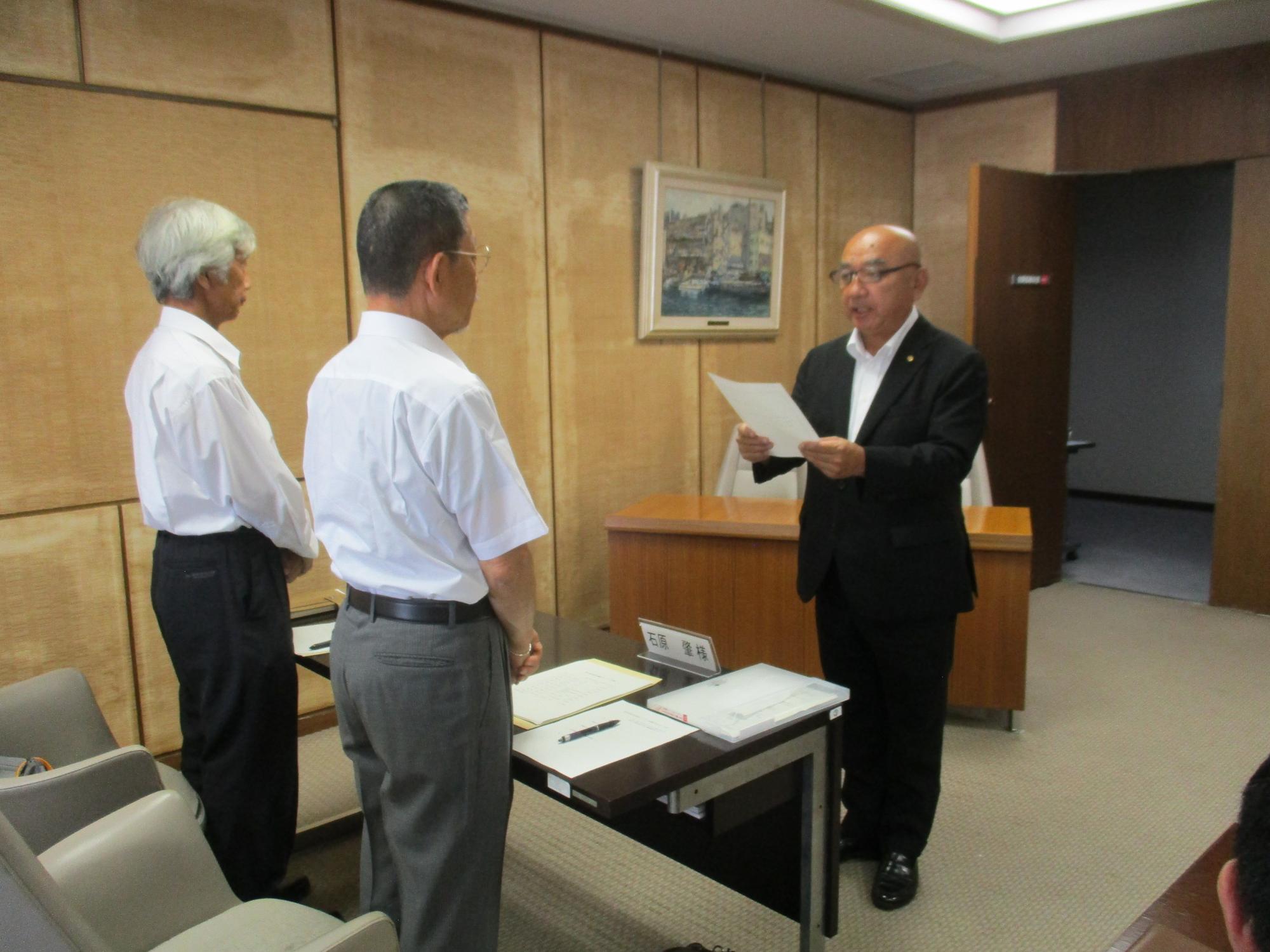 第8期加須市議会モニター委嘱状交付式写真(議長から市民へ委嘱状を交付しているところ）