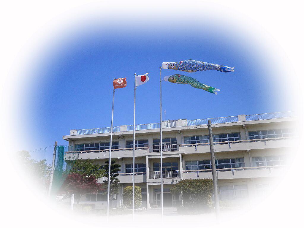 校舎の手前に旗と鯉のぼりがたなびく写真